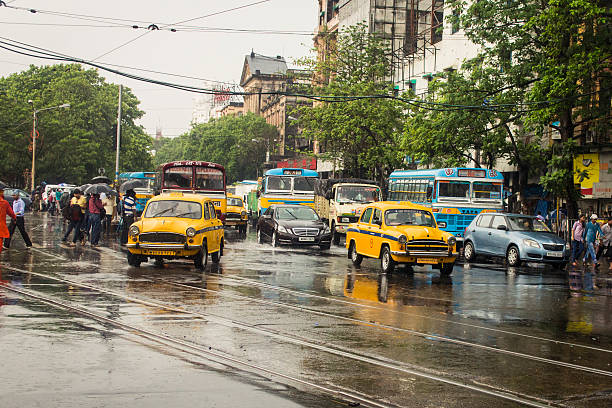 It's raining in Kolkata! This is a typical monsoon afternoon in Kolkata. It was still raining while I ttok the picture so in the picture people are crossing the streets with umbrelas.  Shot near Esplande street in Kolkata. kolkata stock pictures, royalty-free photos & images