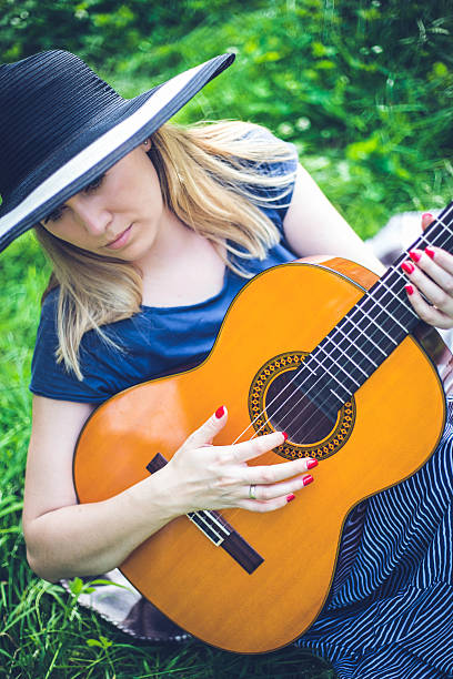 istock beautiful girl playing the guitar 624873050
