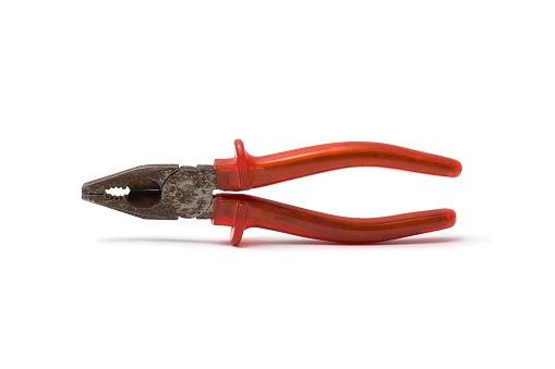 Old rusti plier with red isolation handle on white background