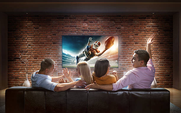 istock Couples watching American football game at home 624873952