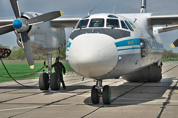 Ukrainian Air Force An-26 Vasilkov, Ukraine - April 24, 2012: Ukraine Air Force Antonov An-26 cargo plane is preparing to start the engines with the starter vehicle on the airfield antonov an 26 stock pictures, royalty-free photos & images