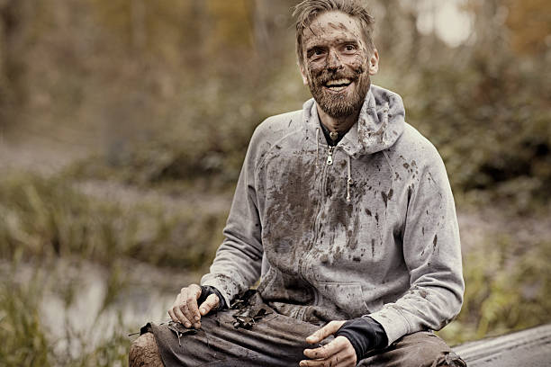 istock Caucasian blonde handsome man sitting smiling during a mud run 624874880