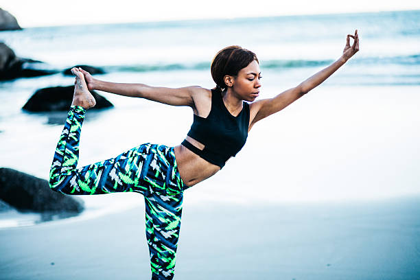 istock African women doing yoga pose on beach 624875624