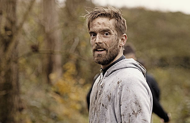 caucasian blonde handsome man posing during a mud run - mud run imagens e fotografias de stock