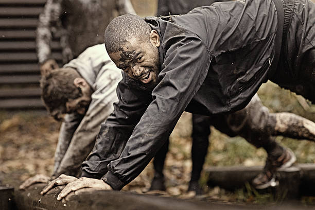 istock Multiethnic mud run team of men climbing along obstacle course 624878728