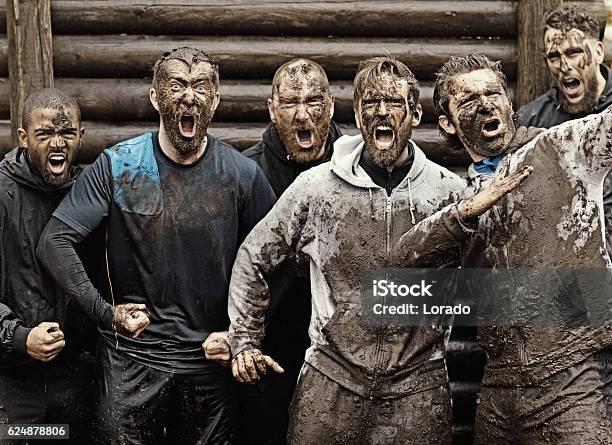 Multiethnic Mud Run Team Of Men Yelling During Obstacle Course Stock Photo - Download Image Now