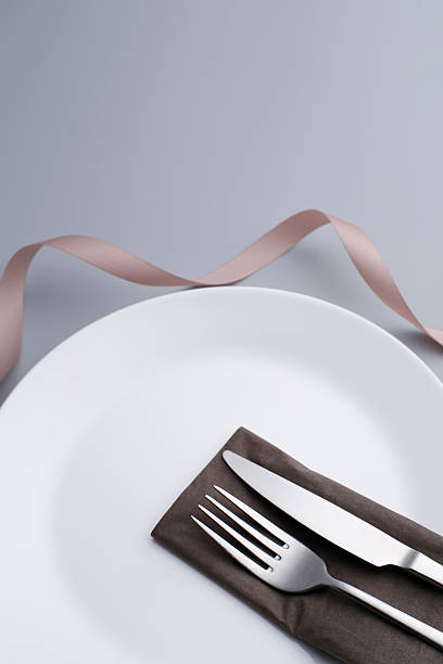 istock Special dinner set. Fork,  Knife and nappkin ribbon flower shape 624879044