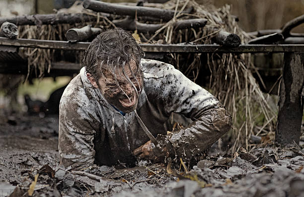 istock Caucasian brunette handsome man crawling under obstacle during mud run 624879728