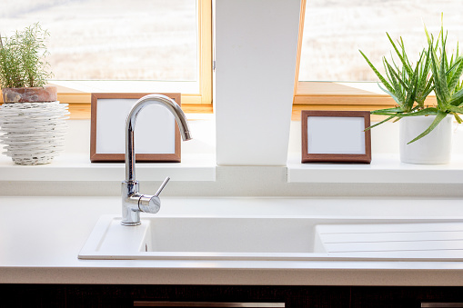 Kitchen sink and faucet in front of a window. Common things in and around the house