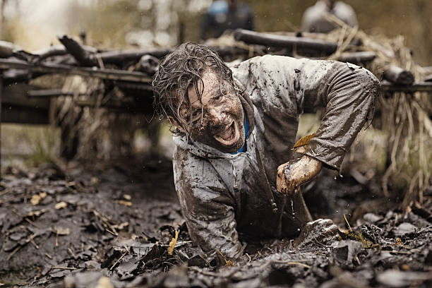 istock Caucasian brunette handsome man crawling under obstacle during mud run 624879852