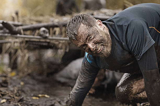 istock Caucasian blonde handsome man crawling under obstacle during mud run 624880072