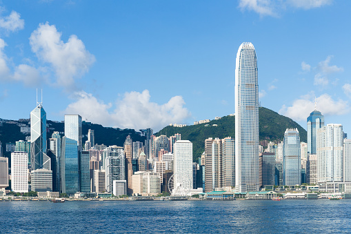 Skyscraper buildings in financial business district Hong Kong island, boat ship traffic transportation at Victoria Harbour. Drone aerial cityscape view. Asia travel tourism landmark concept