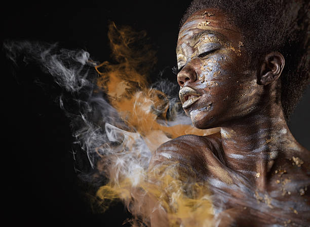 Fashion makeup Young African American woman with silver and gold make-up and body art on a black background with smoke body paint stock pictures, royalty-free photos & images