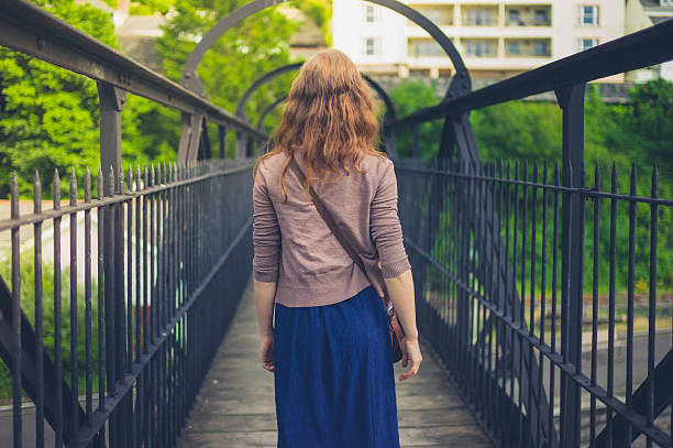 istock Young woman walking on steel bridge 624889946