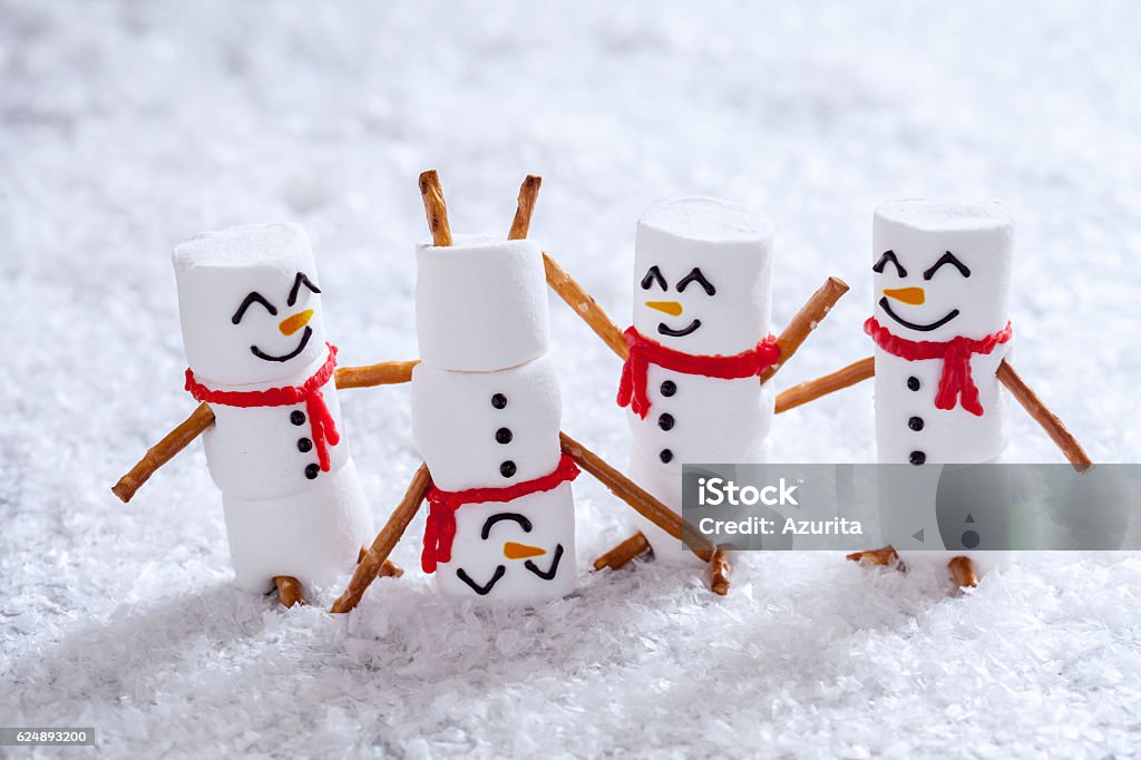 Happy funny marshmallow snowmans on snow Happy funny marshmallow snowmans are having fun in snow Christmas Stock Photo