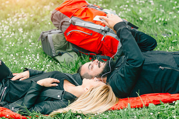 istock Young Couple Backpackers Lying On The Grass And Making Selfie. 624893326