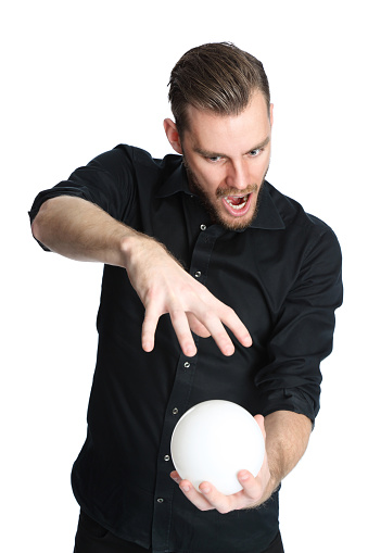 Terrified man wearing a black shirt holding a glass ball looking in to the future. White background.