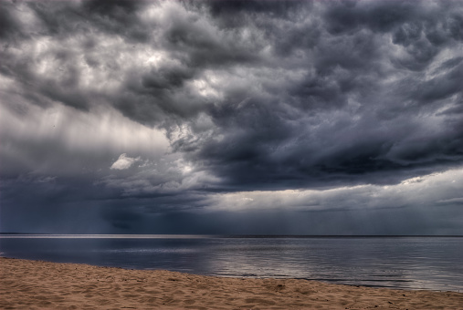 Dark Storm clouds over the sea with light beaming through