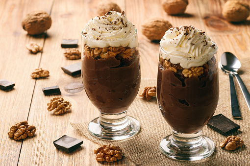 Chocolate pudding with walnuts and whipped cream.
