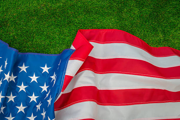 istock American flag on green grass 624898432