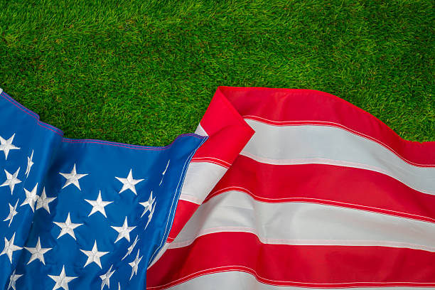 istock American flag on green grass 624898598