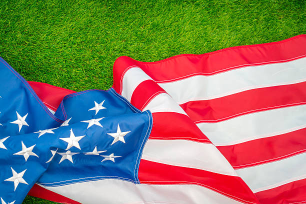 istock American flag on green grass 624909324
