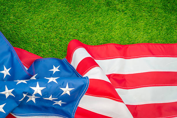 istock American flag on green grass 624911168