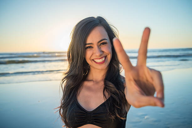 istock Young Hispanic Women On The Beach Peace Sign 624911660