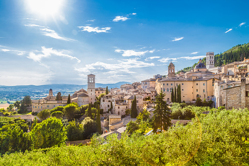 Panoramic view of the historic town of Assisi on a beautiful sunny day with blue sky and clouds in summer, Umbria, Italy.