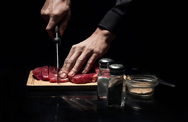 Close up of chefs hands chopping meat
