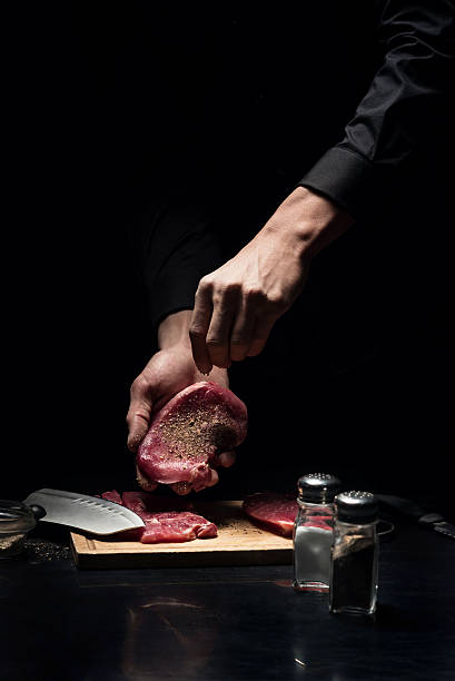 istock Close up of chefs hands spicing the meat 624923464