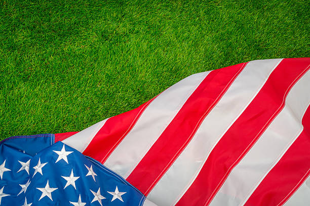 istock American flag on green grass 624925298