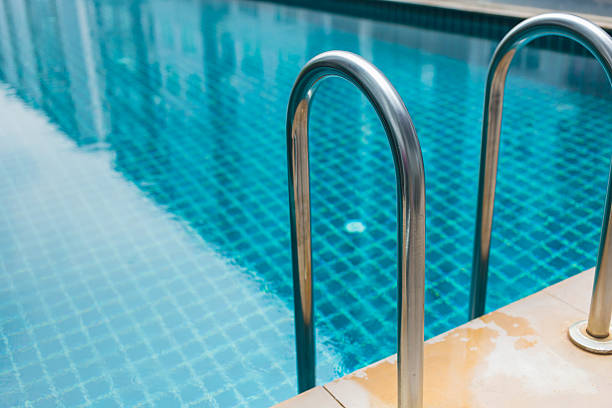 istock blue swimming pool with condominium reflect in the water. 624929288