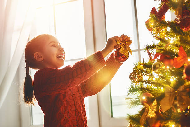 istock girl is decorating the Christmas tree 624930012