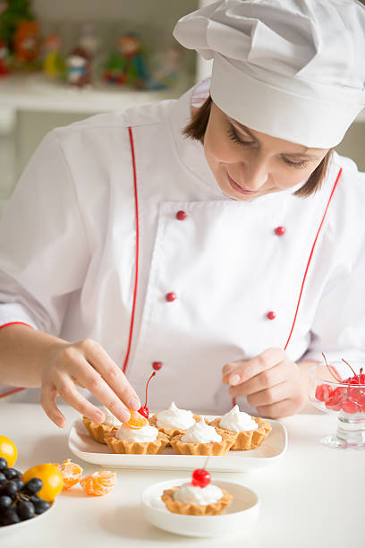 istock Professional female confectioner decorating mini fruit tarts 624946792