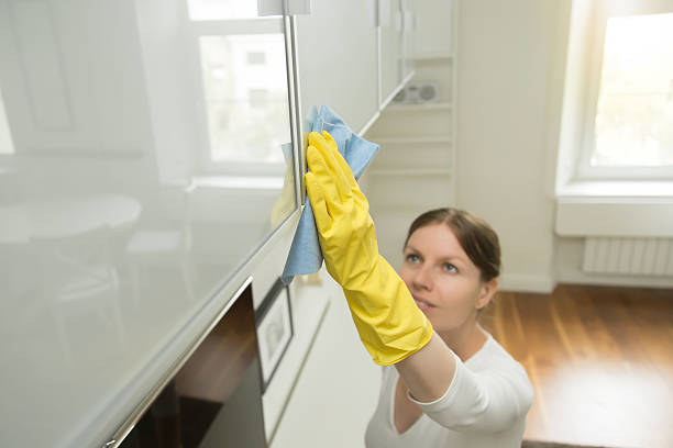 istock Young attractive woman cleaning an upper surface of kitchen clos 624948294