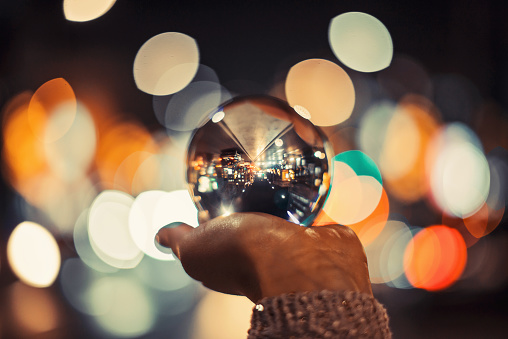 Girl in city holding crystal ball with beautiful bokeh