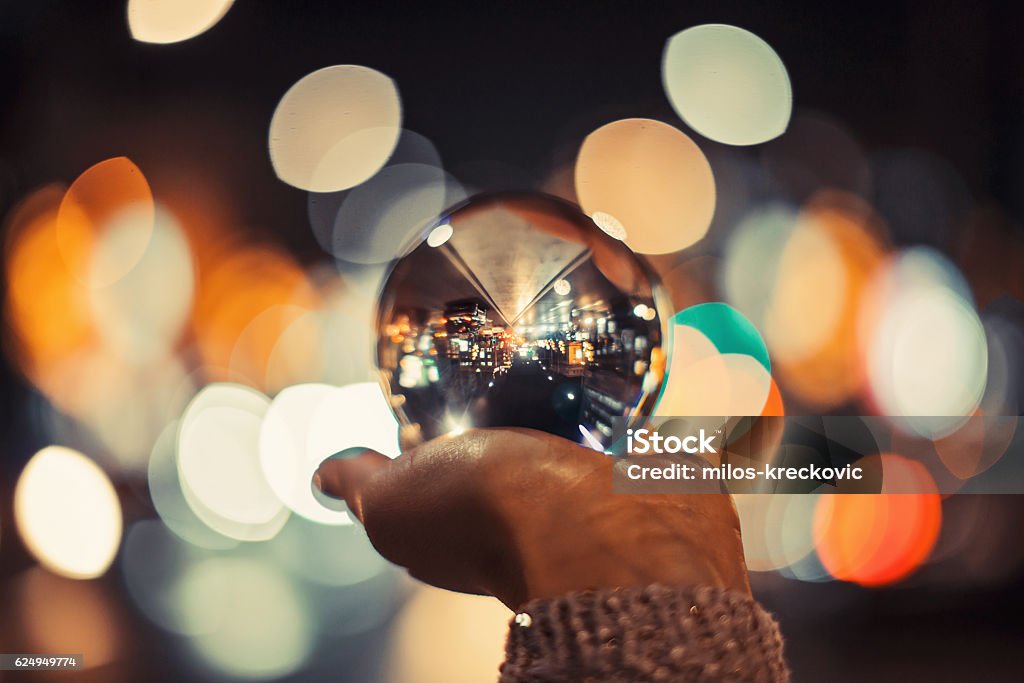 Girl holding crystal ball Girl in city holding crystal ball with beautiful bokeh Crystal Ball Stock Photo