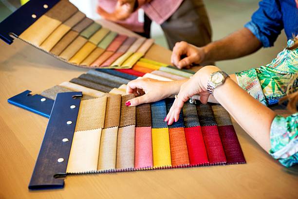 sales clerk showing fabric swatches - furniture store furniture retail textile imagens e fotografias de stock