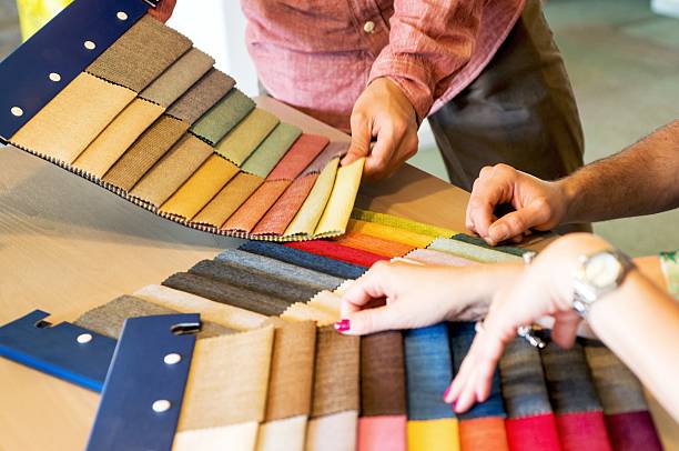 istock Sales Clerk Showing Fabric Swatches 624957934