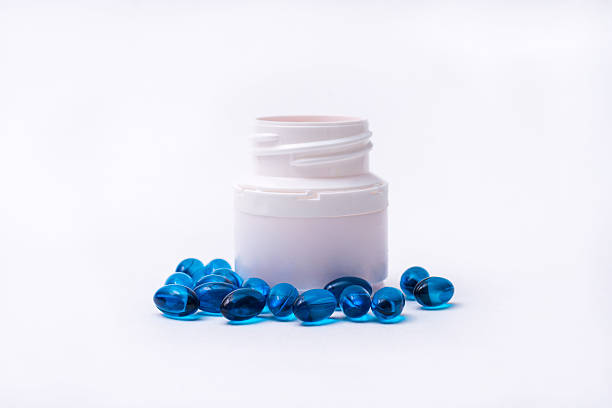 istock Blue pills and medicine bottle isolated on white background. 624959724