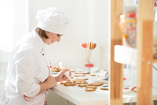 istock Professional female confectioner sitting and decorating a ginger 624967356