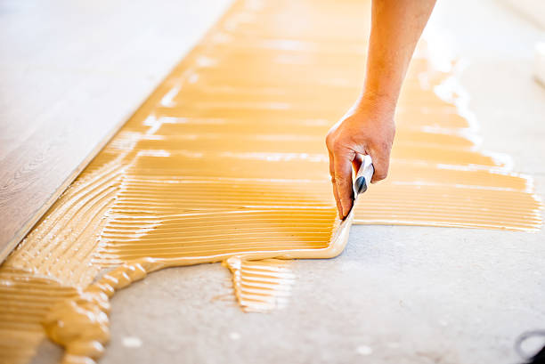 마루 설치 중 접착제를 추가하는 작업자의 손 클로즈업 - repairing floor glue wood 뉴스 사진 이미지