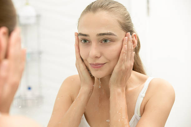 young girl after washing her face water near the sink - gezicht wassen stockfoto's en -beelden