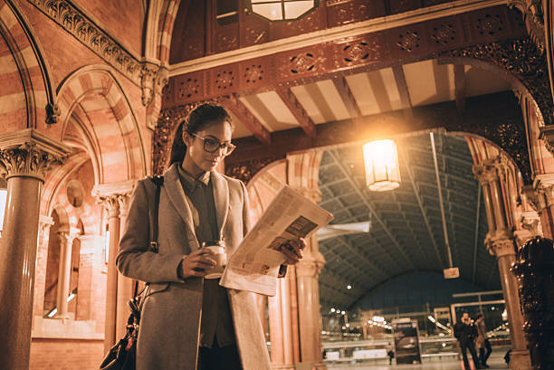 istock businesswoman reading newspaper after work 624975544