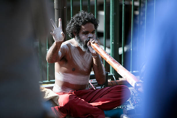 busker sentado e soprando didgeridoo - etnia aborígene australiana ilustrações - fotografias e filmes do acervo
