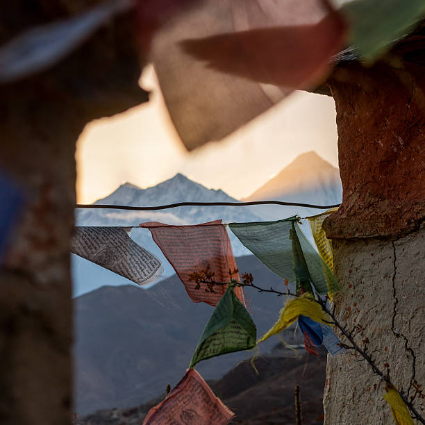 Mountain sunset thorugh a windows of buddhist flags. Dhaulagiri above Muktinath.