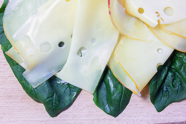 Maasdam cheese and spinach on a wooden board