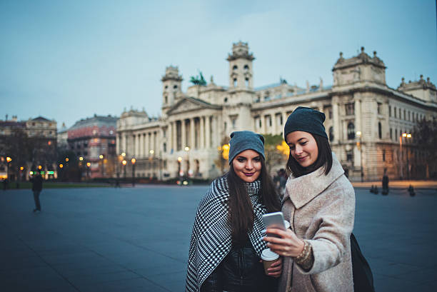 istock girls texting on the phone in Budapest 624988594