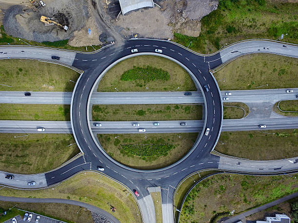 Roundabaout aerial Aerial image of a roundabaout over a 4 lane highway, cars on the road and road construction to the side antenna aerial photos stock pictures, royalty-free photos & images